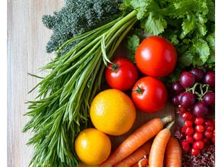 Fresh, vibrant fruits and vegetables artfully arranged on a wooden table, suggesting healthy eating and natural energy.