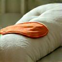 Comfortable bed with soft pillows and a sleep mask